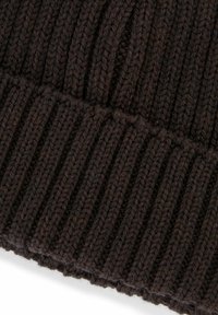 Berretto lavorato a maglia nero con texture a coste, caratterizzato da un orlo arrotolato. Filato spesso, punti uniformi e materiale pesante per garantire calore.