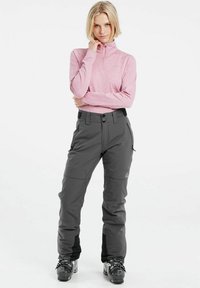 Gray ski pants with a relaxed fit, featuring zippered side pockets and a mid-rise design, paired with a light pink long-sleeve zip-up top.