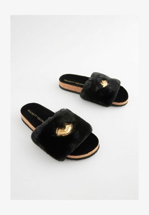 Černé kožené pantofle na korkové podrážce. Obsahují zlatý akcent na pásku a měkkou texturu pro pohodlí.
