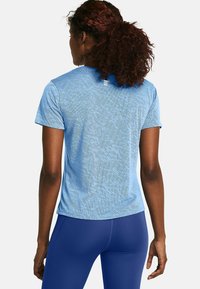 Hellblaues Sportshirt mit strukturiertem Muster, kurzen Ärmeln und rundem Halsausschnitt, kombiniert mit dunkelblauen Leggings.