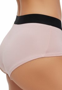 Lichtroze ondergoed met een zwarte elastische tailleband, voorzien van een gladde textuur en een naadloos ontwerp.