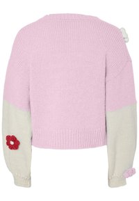 Πλεκτό πουλόβερ με ροζ σώμα και κρεμ μανίκια, ριμπ μανσέτες και λουλουδάτα εφαρμοστά σχέδια σε κόκκινο και λευκό στους άνω βραχίονες.