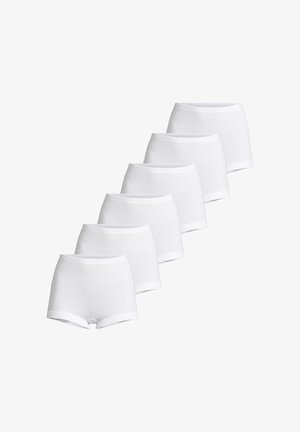 Kuusi paria valkoisia puuvillaisia poikahousuja pinottuna diagonaalisesti valkoista taustaa vasten.