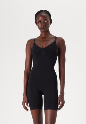 Black bodysuit with adjustable straps, seamless design, and mid-thigh length. Made of stretchy material for a fitted silhouette.