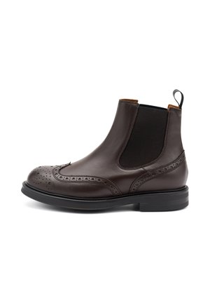 Botín Chelsea de cuero marrón con detalles de brogue, que incluye paneles laterales elásticos y una pestaña para tirar, colocado sobre un fondo blanco.