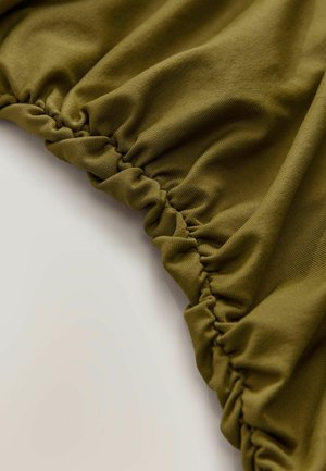 Tkanina olivově zelené barvy s texturovaným povrchem, s nařasenými elastickými okraji pro přiléhavý design. Měkký a pružný materiál.