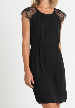 Schwarzes Kleid mit kurzen Ärmeln aus Spitze, einem lockeren Schnitt und einer weichen Textur. Verfügt über einen Boot-Ausschnitt und eine taillierte Passform für eine betonte Silhouette.