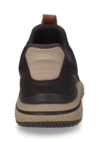 Brauner Slip-On-Sneaker mit einem Mesh-Obermaterial, beiger Sohle und strukturiertem Gummiprofil. Verfügt über eine Rückenschlaufe und "Back-Slip"-Branding.