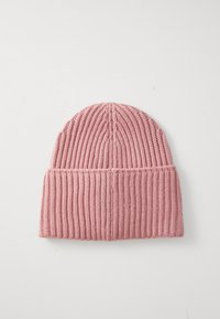 Różowa dzianinowa czapka beanie z zagiętym brzegiem leżąca płasko na białej powierzchni.