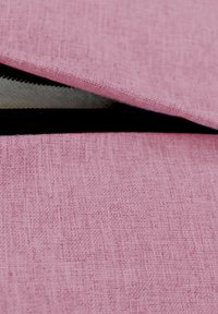 Saquito de tela rosa con una superficie texturizada y una cremallera negra. El saquito parece estar parcialmente abierto, revelando un interior claro.