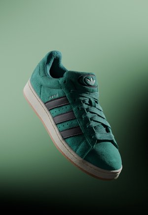 Teal ruskinds sneakers med sorte læder tre striber, hvid sål, polstret krave og klassisk logo på tungen. Struktureret finish.