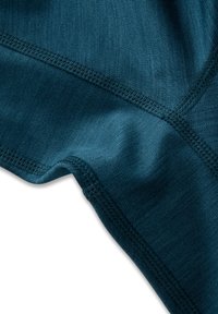 Teal urheilukangas, jossa on sileä pinta ja näkyvät saumat. Suunnittelussa on teksturoitu kuviointi ja saumaton viimeistely.