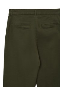 Pantaloni su misura verde scuro con passanti per cintura e due tasche posteriori a filetto orizzontali.