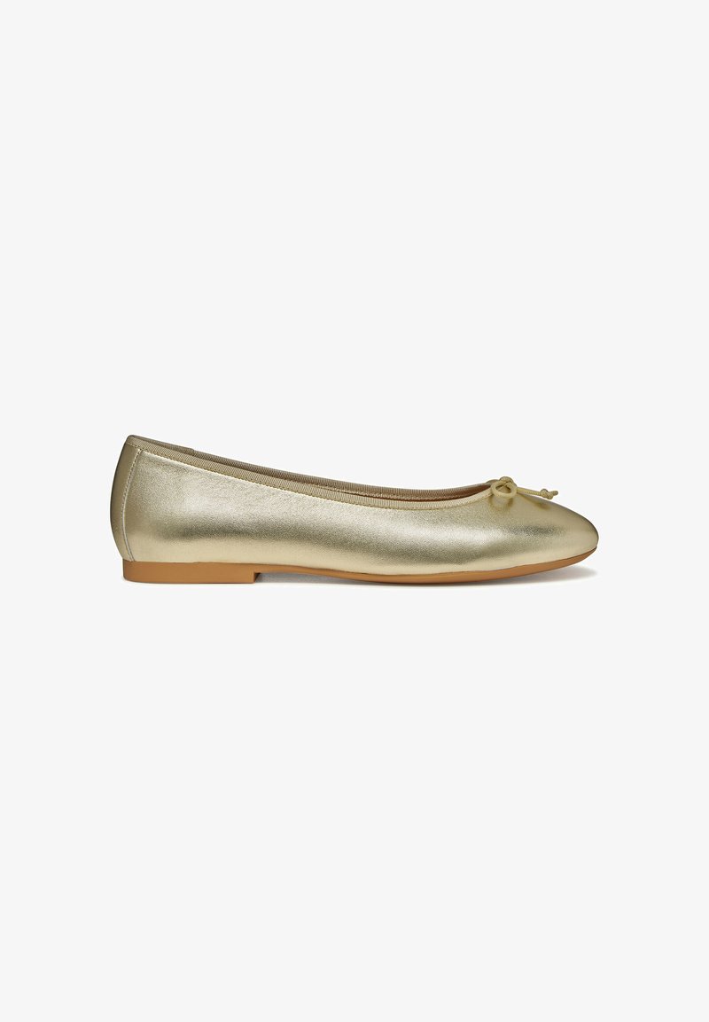 Ballerines métalliques dorées avec un bout arrondi, un petit noeud décoratif et une semelle plate marron. Texture lisse avec un design fin.