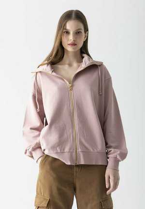 Rosa Zip-Up Hoodie mit hohem Kragen, goldener Reißverschlus und Fronttaschen. Aus weichem Stoff mit einer lockeren Passform und elastischen Ärmelbündchen gefertigt.