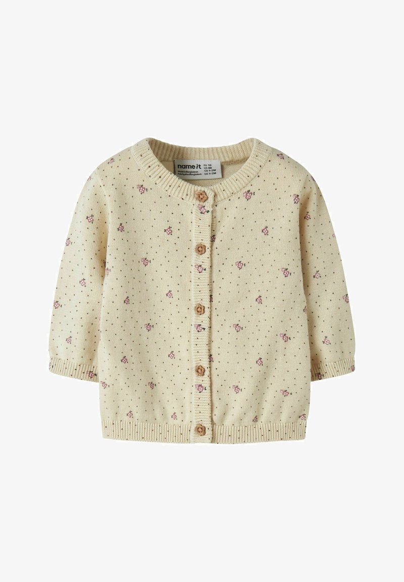 Cardigan bébé crème avec motif floral rose, boutons marron en forme de fleurs, et poignets et ourlet côtelés, taille 1-2 mois.