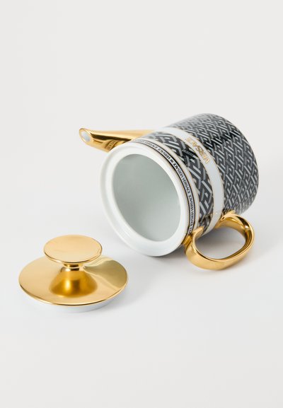 Ceramiczny kubek z czarnym geometrycznym wzorem i złotymi akcentami. Posiada złoty uchwyt oraz dopasowaną pokrywkę. Błyszczące białe wnętrze.