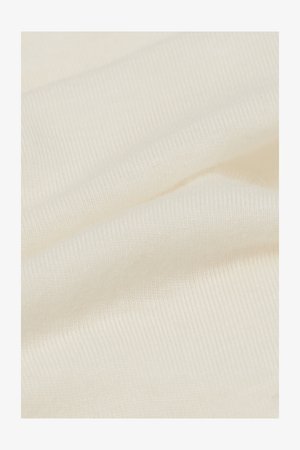 Tessuto di cotone color avorio, con una superficie liscia e leggermente strutturata, caratterizzata da sottili righe e pieghe delicate.