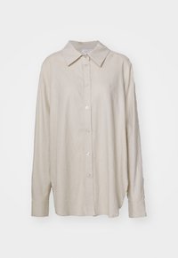Beige linen long-sleeve shirt with a collar, button-front, and subtle logo detail on the left chest. Soft texture and relaxed fit.