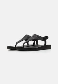 Svart flip-flop sandaler med en teksturert overdel, en flat gummisåle og et minimalistisk design. Ideell for hverdagsbruk.