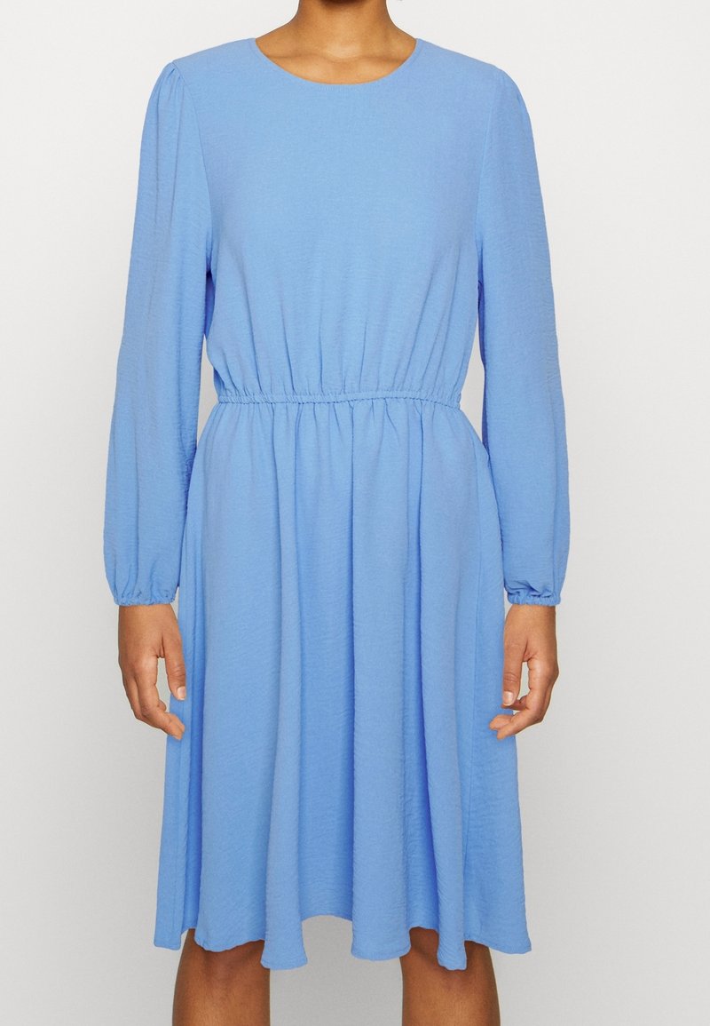 Hellblaues Kleid aus strukturiertem Stoff, mit Rundhalsausschnitt, langen Ärmeln und elastischem Taillenbund für eine ausgestellte Silhouette.