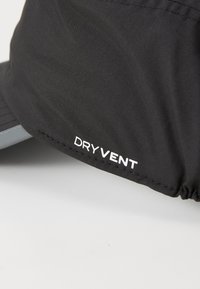 Zwarte stoffen hoed met een hoek die de witte logo-tekst "DRYVENT" op een gladde, getextureerde stof toont, met zichtbare stiksels.