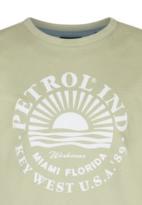 Lichtgroene katoen t-shirt met een witte zonafbeelding met stralen. De tekst bevat "PETROL IND." en "MIAMI FLORIDA KEY WEST U.S.A. '89."