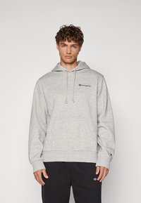 Grauer Baumwoll-Hoodie mit Kängurutasche, verstellbarem Kordelzug an der Kapuze und kleinem blauen gestickten Logo auf der Brust. Gerippte Bündchen und Saum.