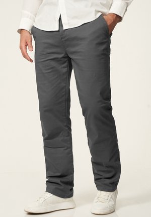 Grey, straight-leg pants made of cotton blend fabric, featuring side pockets and a smooth finish, paired with white sneakers.