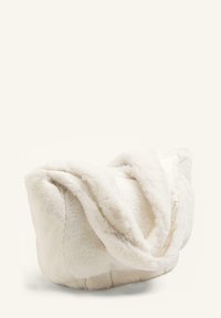 Fuskpälspläd i krämfärg, med mjuk textur och plyschdesign, med lager på lager av veck och rundad form.