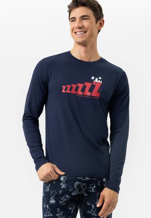 Navy lange mouwen shirt met een rode "zzzz" graphic en Snoopy afbeelding, gecombineerd met gestreepte navy pyjamabroek. Zacht materiaal, casual pasvorm.
