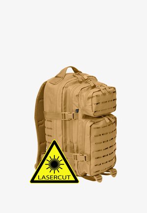 Mochila táctica de color canela con múltiples compartimentos con cremallera y paneles de ventilación cortados con láser, mostrada con una señal de advertencia amarilla cortada con láser.