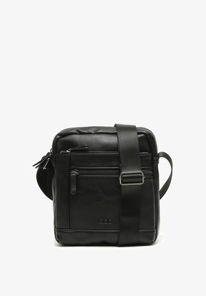 Czarna skórzana torba crossbody z przednią kieszenią na zamek i regulowanym paskiem. Charakteryzuje się gładką teksturą i minimalistycznym designem.