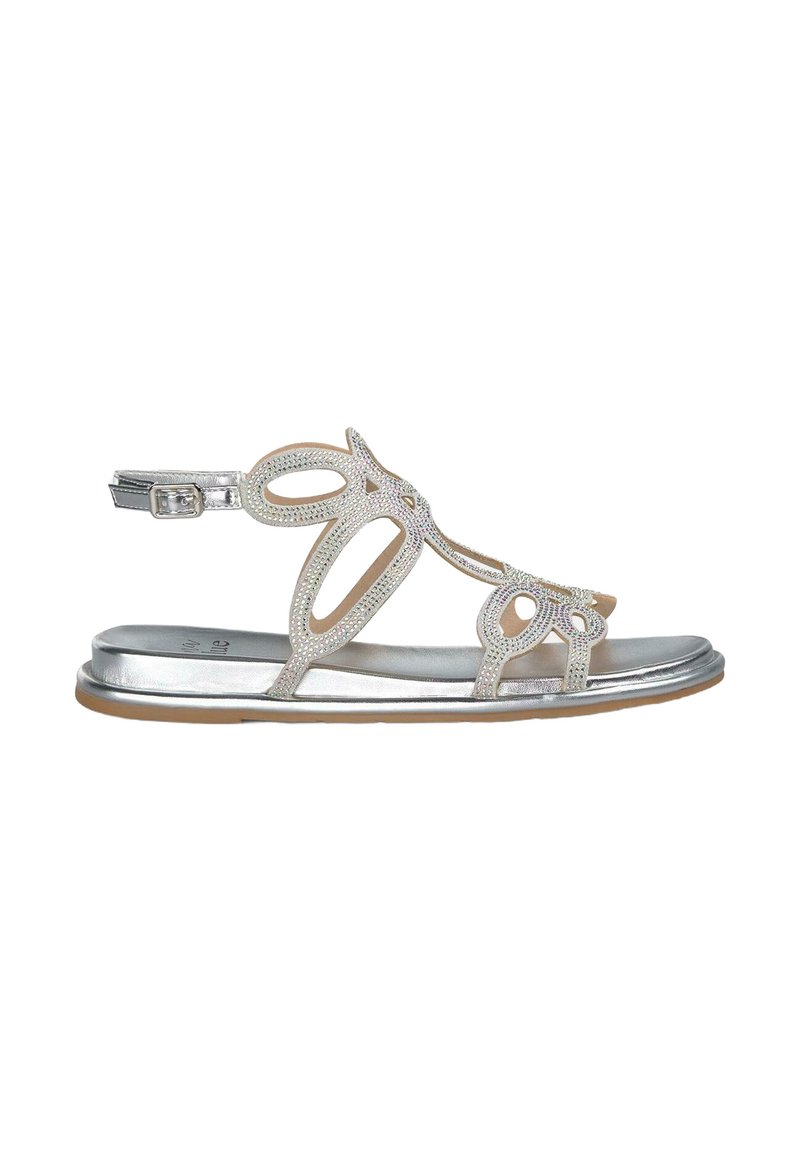 Silberne flache Sandalen mit dekorativem Cut-Out-Design und Strass-Akzenten. Schnallenverschluss am Riemen um das Knöchel und eine glatte metallische Fußbett.