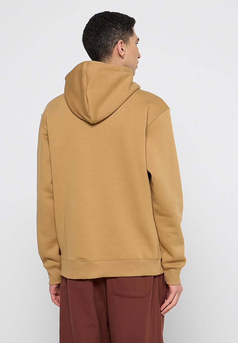 Sweatshirt à capuche de couleur sable, fabriqué à partir d'un tissu doux. Présente une coupe décontractée et des manches à poignets, avec une poche kangourou à l'avant.