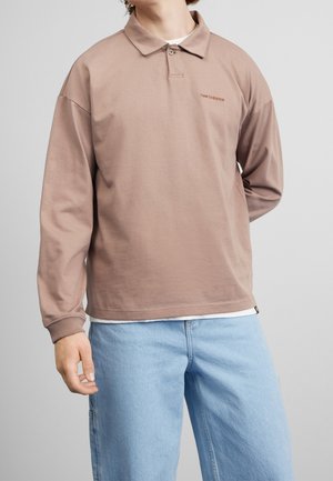 Braunes langärmliges Poloshirt mit einem geknöpften Kragen und einem kleinen Logo. Verfügt über eine lockere Passform mit weichem Stoff und gerippten Bündchen. Wird über einem weißen Unterhemd getragen.