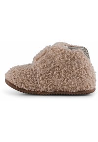 Pantofole beige morbide con una texture soffice e ricciolosa, forma tondeggiante e suola di gomma. Accentate da un tessuto stampato sul retro.