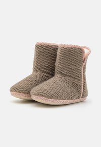 Brown knitted slippers with pink accents and textured finish. Short height with a rounded toe and patterned sole for traction.