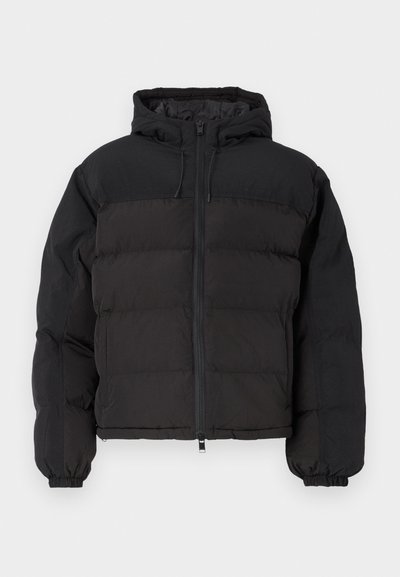 Jachetă puffer neagră cu glugă, închidere cu fermoar, manșete elastice și o formă pătrată, cu secțiuni matlasate pentru izolație.