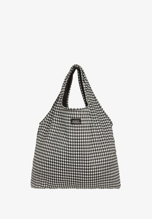 Kassi musta-valkoista ruudullista kangasta, jossa on lörpähtävä muoto, kaksi pitkää kahvaa ja pieni musta logotunnus. Materiaali näyttää pehmeältä ja kevyeltä.