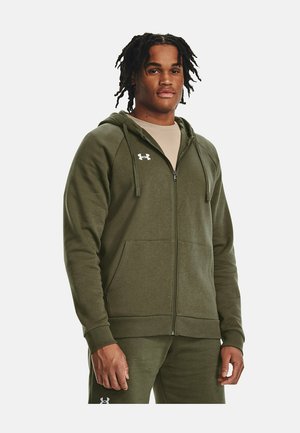 Felpa con zip verde oliva realizzata in un tessuto morbido e testurizzato, dotata di tasca frontale, cappuccio con coulisse regolabile e logo sul petto.