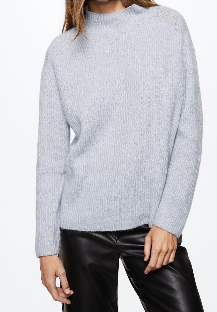 Maglione a coste di un delicato blu chiaro con collo alto e maniche lunghe, realizzato in un morbido materiale testurizzato. Abbinato a pantaloni neri.