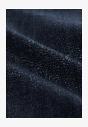 Dark denim fabric displaying a smooth texture with subtle shimmer. The material features a classic twill weave and a deep navy color.