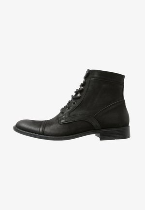 Bottes chevilles en cuir noir avec un bout arrondi, un laçage et une finition texturée ; comporte un petit talon empilé et des accents sur les panneaux latéraux.