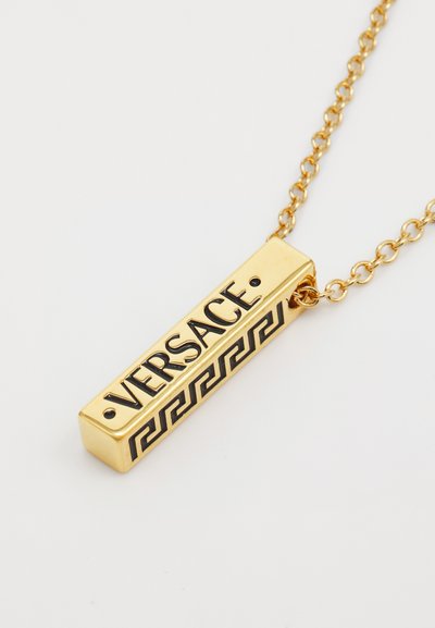 Zelta kaklarota ar taisnstūra piekariņu, kurā melnā krāsā ir iegravēts "VERSACE", apakšmalā ietverts melns grieķu atslēgas raksts.