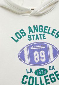 Vit hoodie med dragsko, med grön och lila grafisk tryck: "LOS ANGELES STATE COLLEGE" med en fotboll och nummer "89."