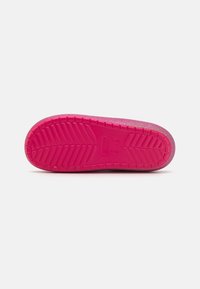 Roza-rubber podplat z teksturiranim tread vzorcem, s svetlikajočo obdelavo in zaobljeno obliko. Vidni znaki za blagovno znamko in velikost.