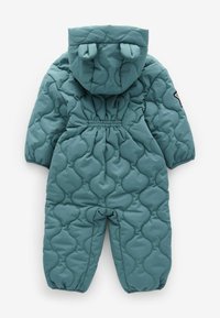 Combinaison de neige isolée en teal, présentant une texture matelassée, un design arrondi et gonflé, une taille élastique, et une capuche avec des accents en forme d'oreilles.
