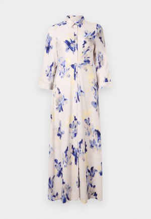 Une robe longue florale présente des fleurs bleu et jaune sur un fond clair, avec un devant à boutons et un col.