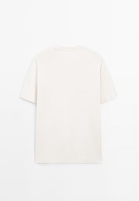 T-shirt med kort ärm i en mjuk beige färg, tillverkad av bomull, med rund halsringning och avslappnad passform. Bakifrån visar den en enkel design.